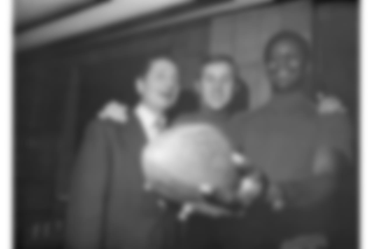 Allie Sherman, left, coach of the New York Giants, quarterback Fran Tarkenton, center, and flankerback Homer Jones, beam at an autographed pigskin at Yankee Stadium in New York, Nov. 12, 1968. The trio were still jubilant over the Giants' victory over the Dallas Cowboys on Nov. 10. (AP Photo/Harry Harris)