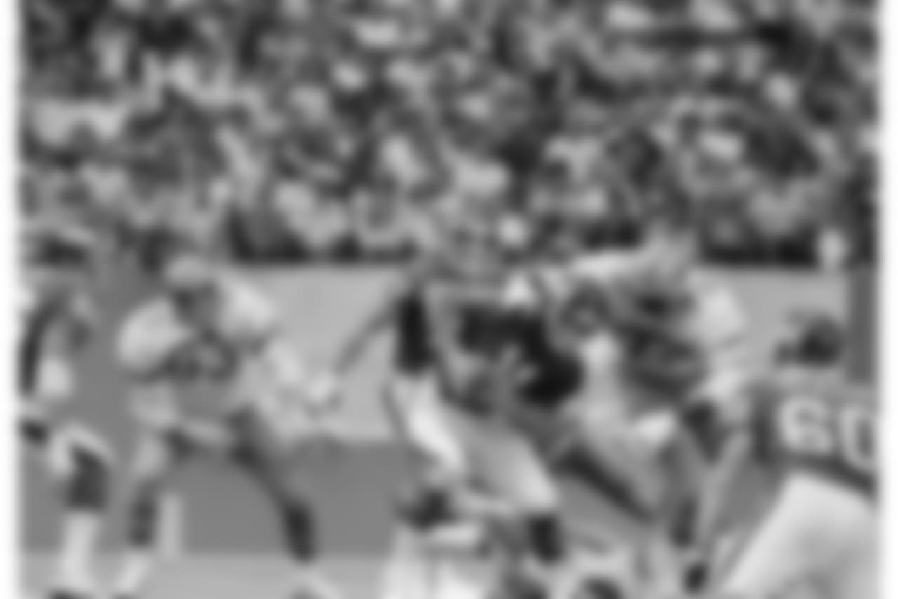 New York Giants quarterback Phil Simms (11) scrambles to escape Dallas Cowboys defensive end Ed "Too Tall" Jones (72) in the third quarter of a game at Texas Stadium in Irving, Tex., Oct. 5, 1980. (AP Photo/Ron Heflin)