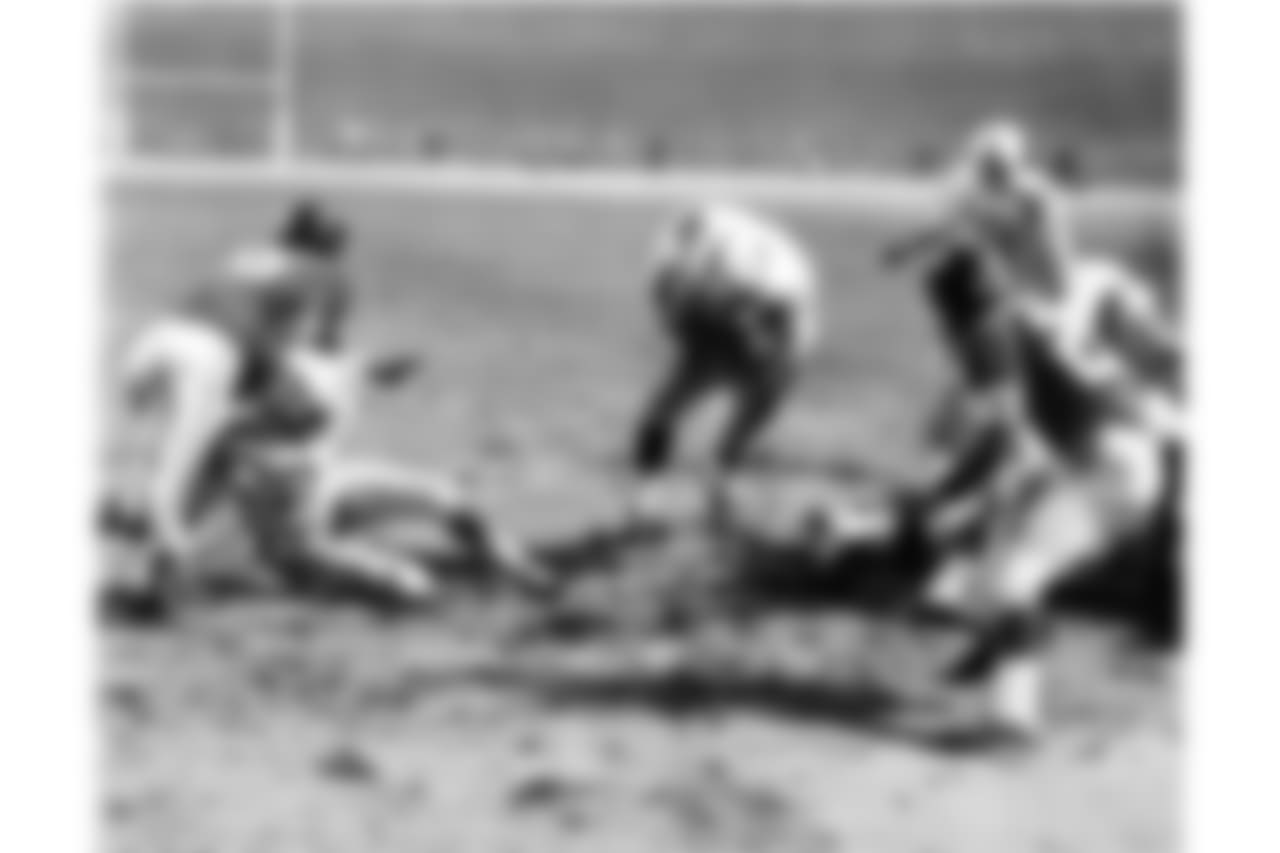 Baltimore Colts fullback Alan Ameche advances through a big opening provided by teammates to score the winning touchdown in overtime period against the New York Giants at Yankee Stadium in New York, Dec. 28, 1958. Colts' Lenny Moore gets a good block on Giants' Emlen Tunnell (45) at left. Colts quarterback Johnny Unitas (19) is at right along with Giants' Jim Patton (20). Batimore won, 23-17, for National Football League title in the first overtime finish in title history. (AP Photo)