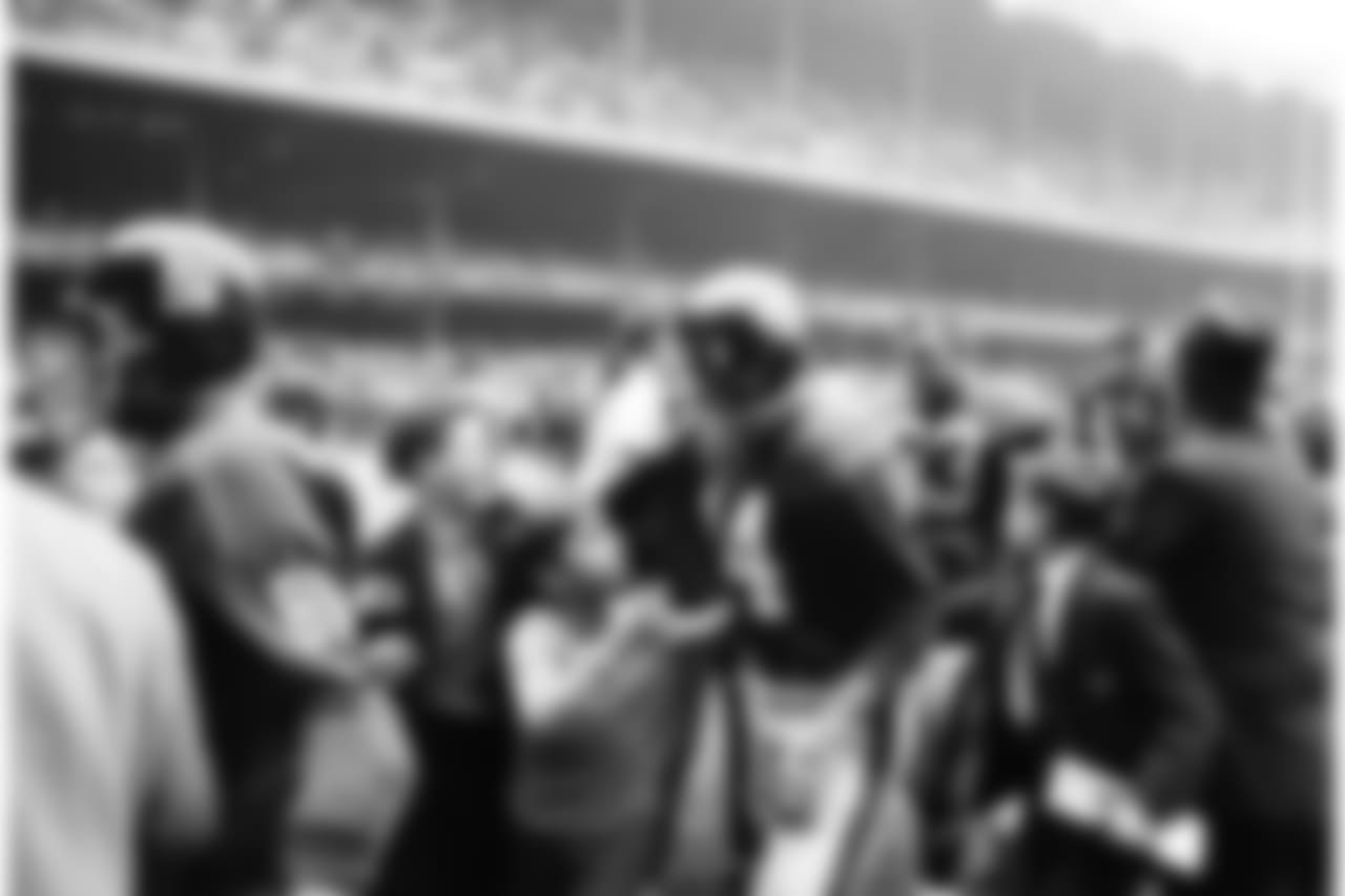 Y.A. Tittle the hero is used to receiving attention and adulation wherever he goes. Here admiring young fans escort him from the field after a victory over the Dallas Cowboys, Nov. 12, 1963. (AP Photo/Ruben Goldberg)