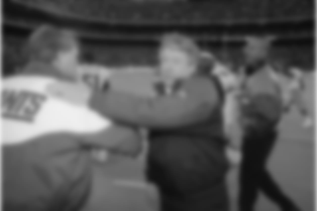 New York Giants coach Dan Reeves receives a pat on the back from Dallas Cowboys coach Jimmy Johnson after the Cowboys defeated the Giants 16-13 in overtime at Giants Stadium in East Rutherford, New Jersey, on Sunday, Jan. 2, 1994. The win gives the Cowboys the NFC East Division title. (AP Photo/Charles Rex Arbogast)