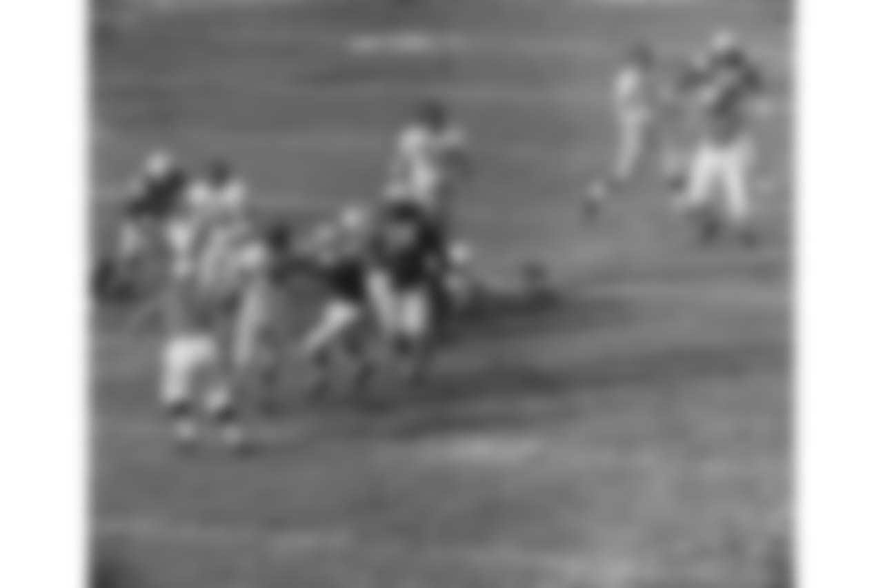 Charles Conerly, 42, New York Giants' quarterback, is grabbed by Gino Marchetti, Baltimore Colts' end, as he tries to pass in the first period on Dec. 27, 1959 in Baltimore. Cornerly couldn't get the ball away and was dropped for a 20 yard loss. No. 76 at right is Gene Lipscomb of the Colts. (AP Photo)