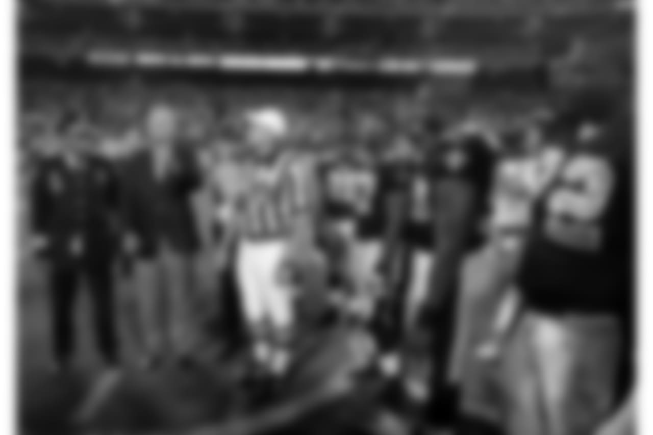 Former United States President George Bush, second from left, flips the ceremonial coin as New Orleans Police Superintendant Eddie Campos, left, and referee Ed Hochuli (85) look on before the game between the New Orleans Saints and the New York Giants Monday, Sept. 19, 2005 at Giants Stadium in East Rutherford, NJ. Although played in Giants Stadium, the game was a home game for the Saints that was relocated due to the damage from Hurricane Katrina. (AP Photo/Vincent Laforet, Pool)