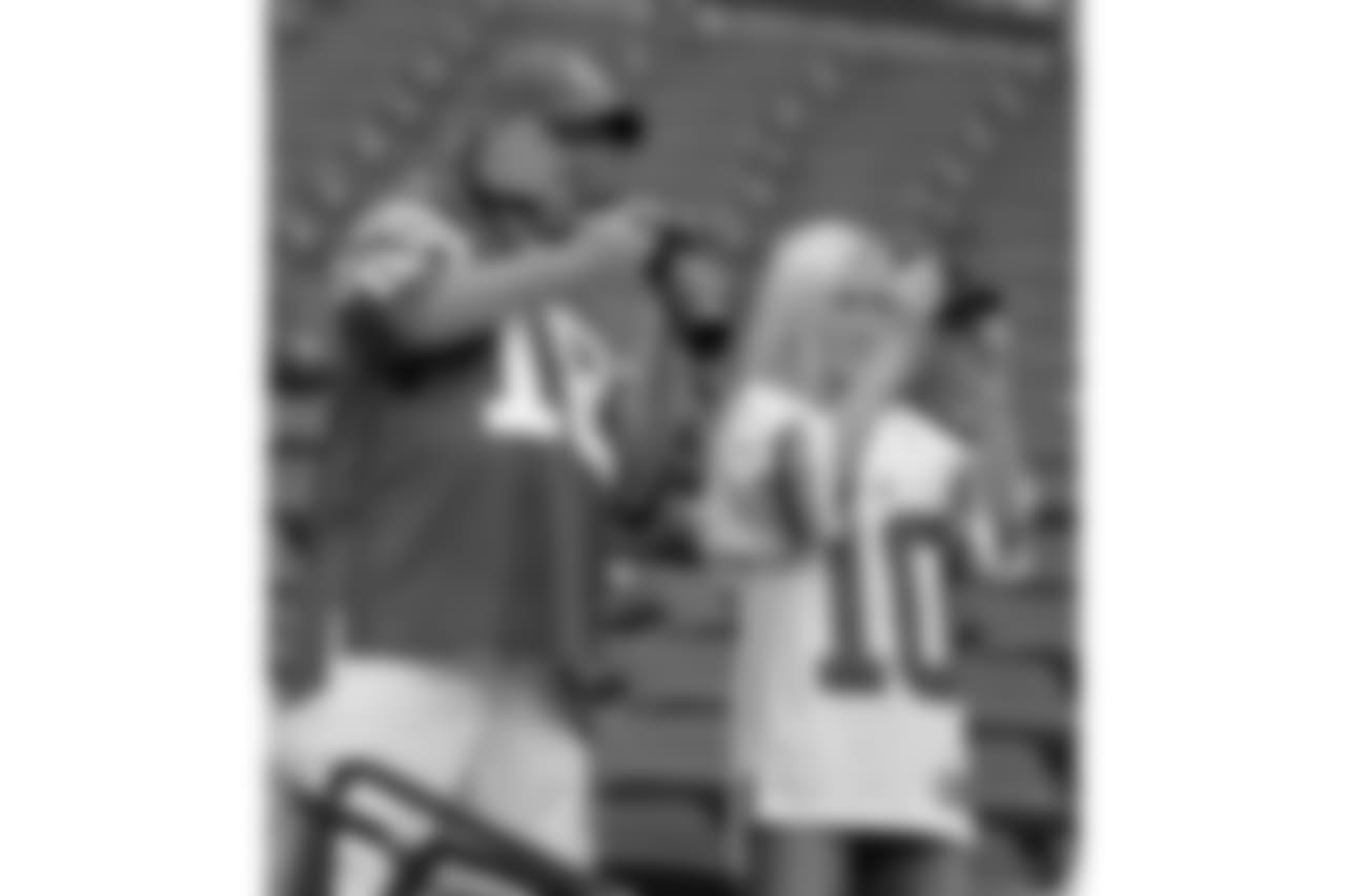 Football fans take photos of Indianapolis Colts quarterback Peyton Manning and New York Giants quarterback Eli Manning as they talk on the field before an NFL football game in Indianapolis, Sunday, Sept. 19, 2010. (AP Photo/Darron Cummings)