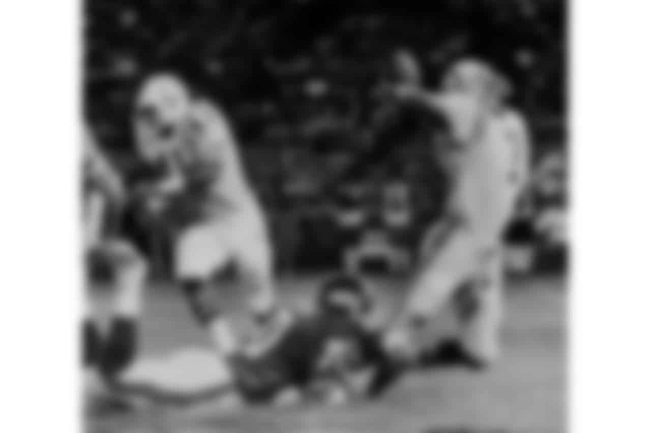 Gary Jeter, defensive end for the New York Giants, dives to the ground and brings down quarterback Bert Jones of the Baltimore Colts as he gets off a pass in the first quarter of their NFL exhibition game in Baltimore, Md., Aug. 22, 1980. The Colt's running back Mark Bailey (41) races to block another Giant defender, as Jones' pass fell incomplete in the end zone. (AP Photo/Joe Giza)