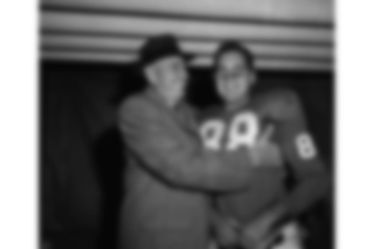 New York Giant coach Jim Lee Howell hugs Allen Pat Summerall in dressing room of Yankee Stadium after Giants defeated Baltimore Colts 24-21 in New York on Nov. 9, 1958. Summerall, with less than 3 minutes to play in game kicked 28-yard field goal to provide winning margin in the game. He also kicked all three points after touchdown for the Giants. The New York team, with season record of 5-2, moved into first place tie with Cleveland Browns in Eastern Division of National Football League. (AP Photo)