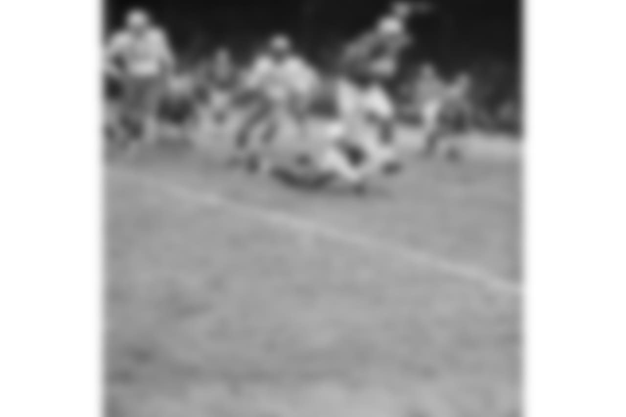Detroit Lions halfback Dan Lewis (45) looks like he is about to be toppled by Chicago Cardinals back Jim Wagstaff (on ground), but Lewis was too fleet for him. He ran a good ten yards more in this fourth quarter play before another player nailed him. At rear is Cardinals linebacker Ted Bates (51). The Lions scored early and kept a healthy lead throughout the game to win 54-21, on Dec. 7, 1959 in Detroit. (AP Photo/AlvinQuinn)