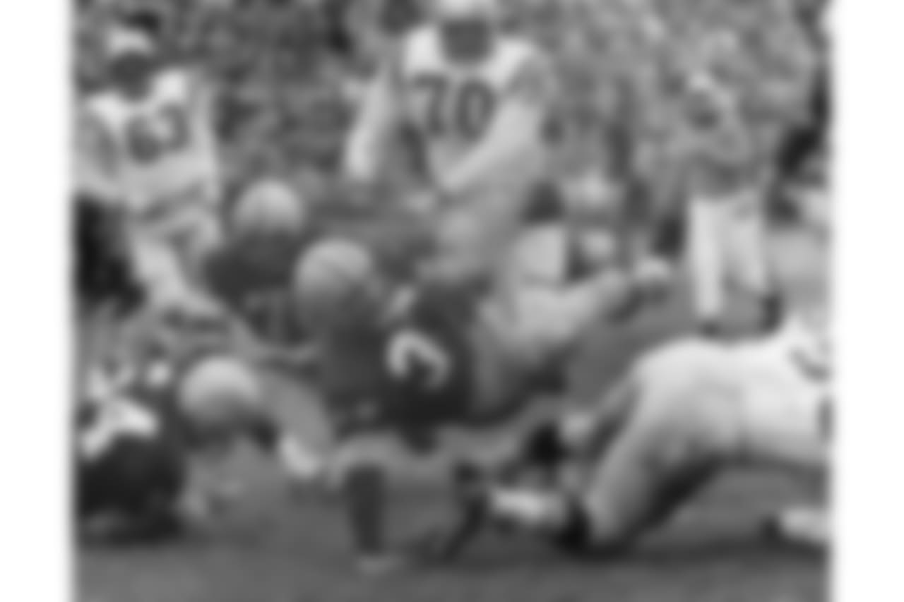 FILE - In this Oct. 11, 1959, file photo, Green Bay Packers halfback Lewis Carpenter (33) is upended by San Francisco 49ers Matt Hazeltine (55) in the second quarter of an NFL football game in Green Bay, Wis. A running back who won three NFL championships in a 10-year career with the Lions, Browns and Packers, Carpenter stuck around the sidelines for another 31 years as an assistant coach. He preached what he heard from Hall of Fame coaches like Vince Lombardi: Walk it off, or we’ll find someone who can. (AP Photo/File)