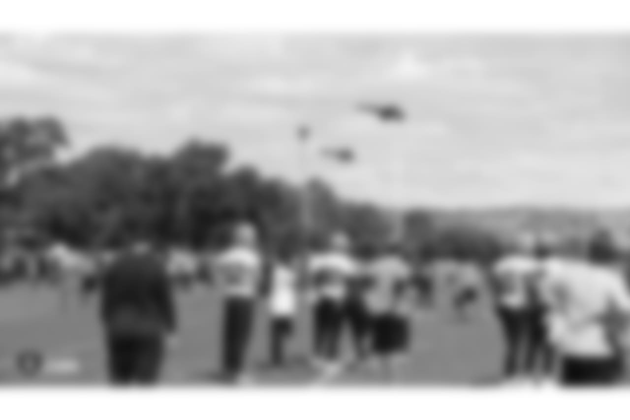 Oakland Raiders players and coaches watch the Blue Angels, the US Navy's flight demonstration squadron, on the field for practice at The Oakland Raiders Practice Facility, Thursday, October 4, 2018, in Alameda, California.