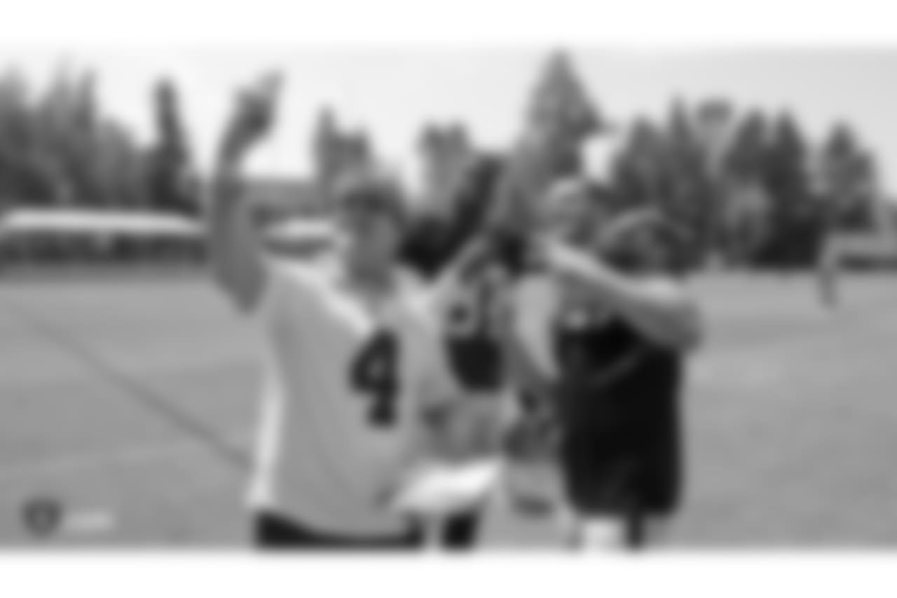 Oakland Raiders tight end Jared Cook (87) and quarterback Derek Carr (4) sign autographs for fans after practice at 2018 Training Camp at The Oakland Raiders Napa Valley Training Complex, Tuesday, August 14, 2018, in Napa, California.