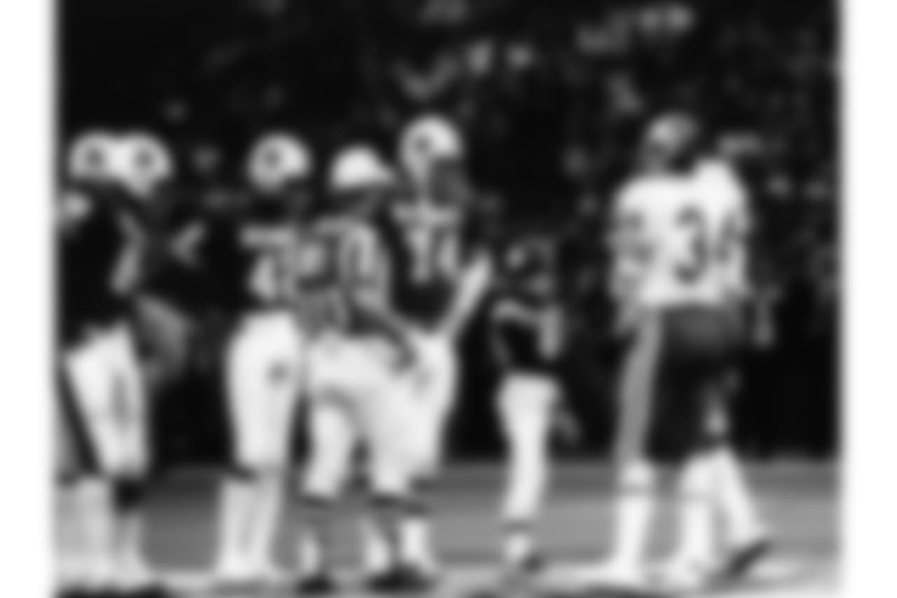 Charley Taylor (42), Merlin Olsen (74), and Andy Russell (34) meet the NFL's Mascot of the Year at midfield for the coin flip prior to the 1976 Pro Bowl in New Orleans on Jan. 26, 1976. The NFC defeated the AFC 23-20. (AP Photo/NFL Photos)