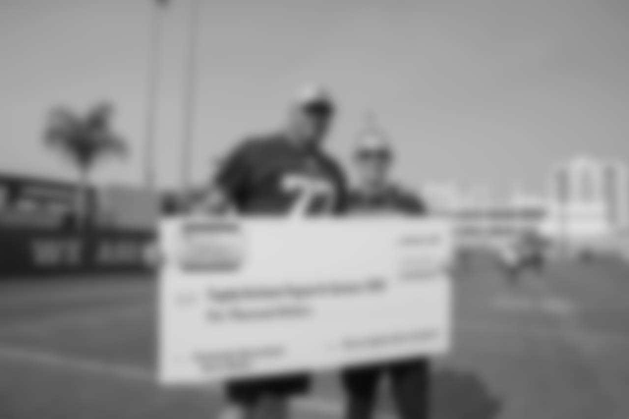 (77) Andrew Whitworth of the Los Angeles Rams poses with a check to the Tragedy Assistance Program for Survivors families with Honda after a walk through , Saturday, November 10, 2018, in Los Angeles, CA. (Jeff Lewis/Rams)