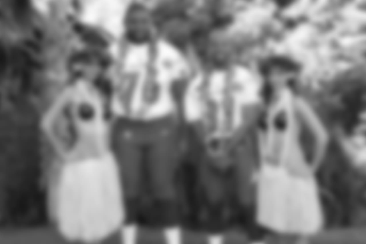 Orlando Pace #76, Torry Holt #81 pose with Hawaiian Hula girls for their 2005 NFL Pro Bowl team photo on February 11, 2005. (AP Photo/Paul Spinelli)