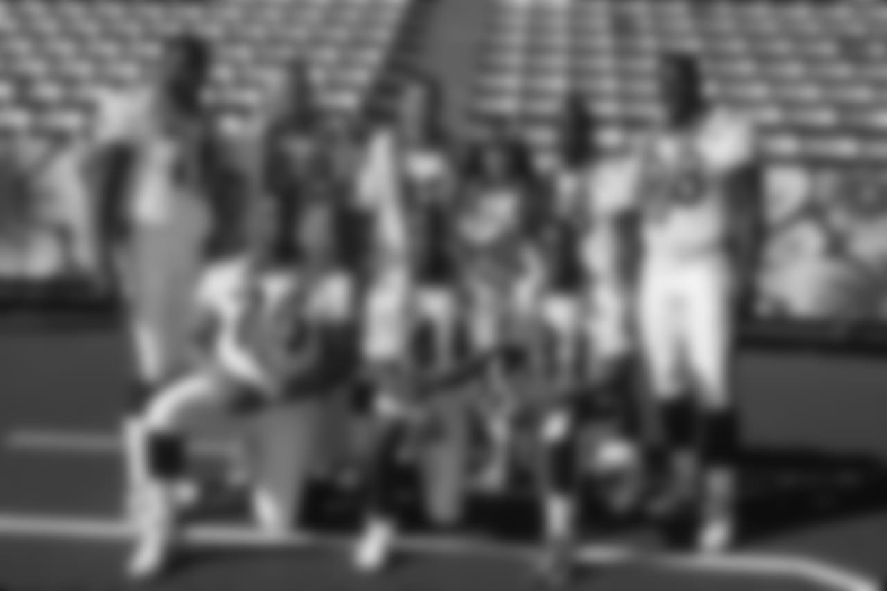 Rams tackle Orlando Pace #75, guard Adam Timmerman #63, quarterback Kurt Warner #13, running back Marshall Faulk #28, defensive end Kevin Carter #98, defensive tackle D'Marco Farr #75, safety Todd Lyght #41 and wide receiver Isaac Bruce #80 pose with a hula girl prior to playing in the 2000 NFL Pro Bowl at Aloha Stadium on February 6, 2000. (AP Photo/NFL Photos)