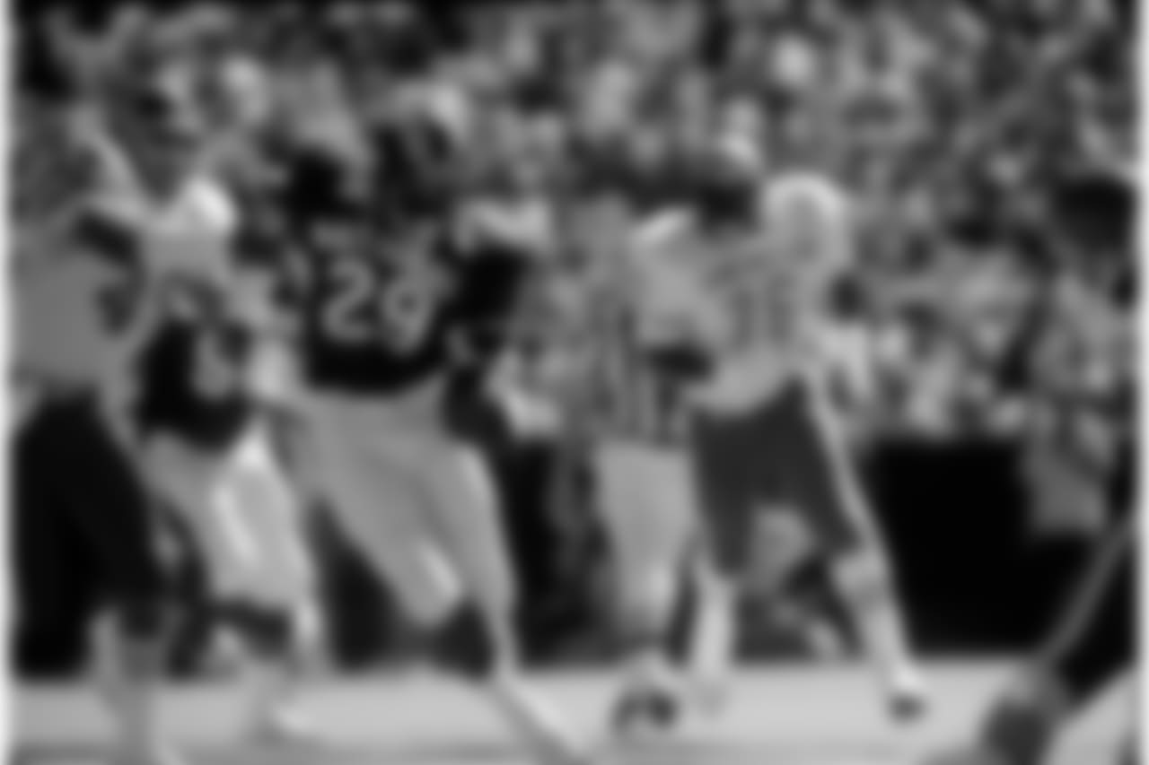 Eric Dickerson (29) of the Rams carries the football before being caught by Denver Broncos safety Dennis Smith (49) during the 1987 NFL Pro Bowl played on February 1, 1987. (AP Photo/NFL Photos)