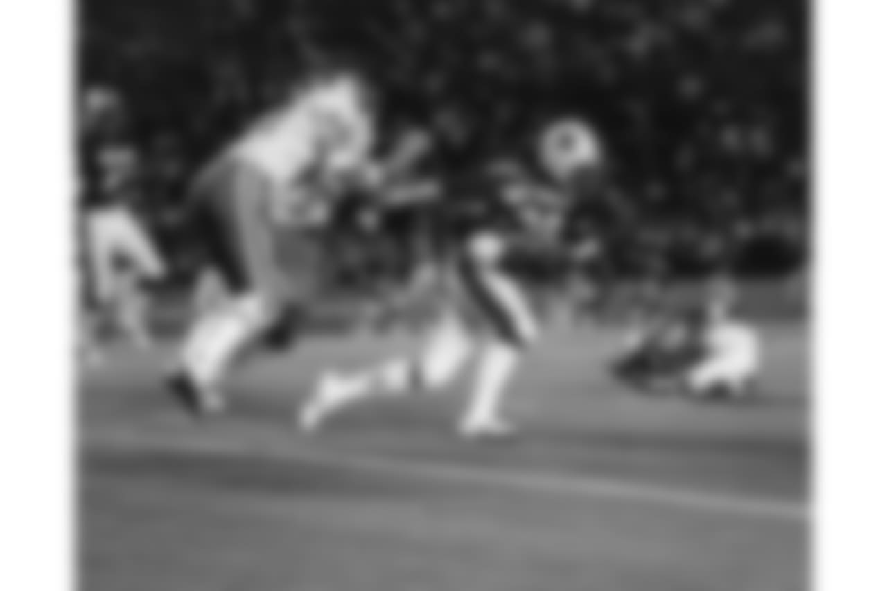 Lawrence McCutcheon (30) is grabbed by the jersey by Dick Anderson (40) during the 1975 NFL Pro Bowl in Miami, Fla. The NFC defeated the AFC 17-10 at the Orange Bowl. (AP Photo/NFL Photos)