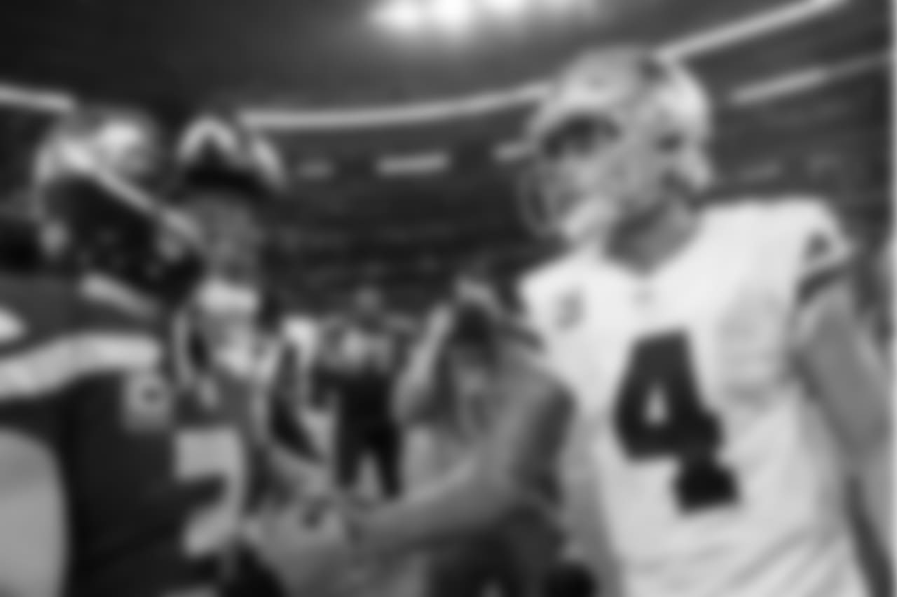 Quarterbacks Russell Wilson and Dak Prescott shake hands after the game.