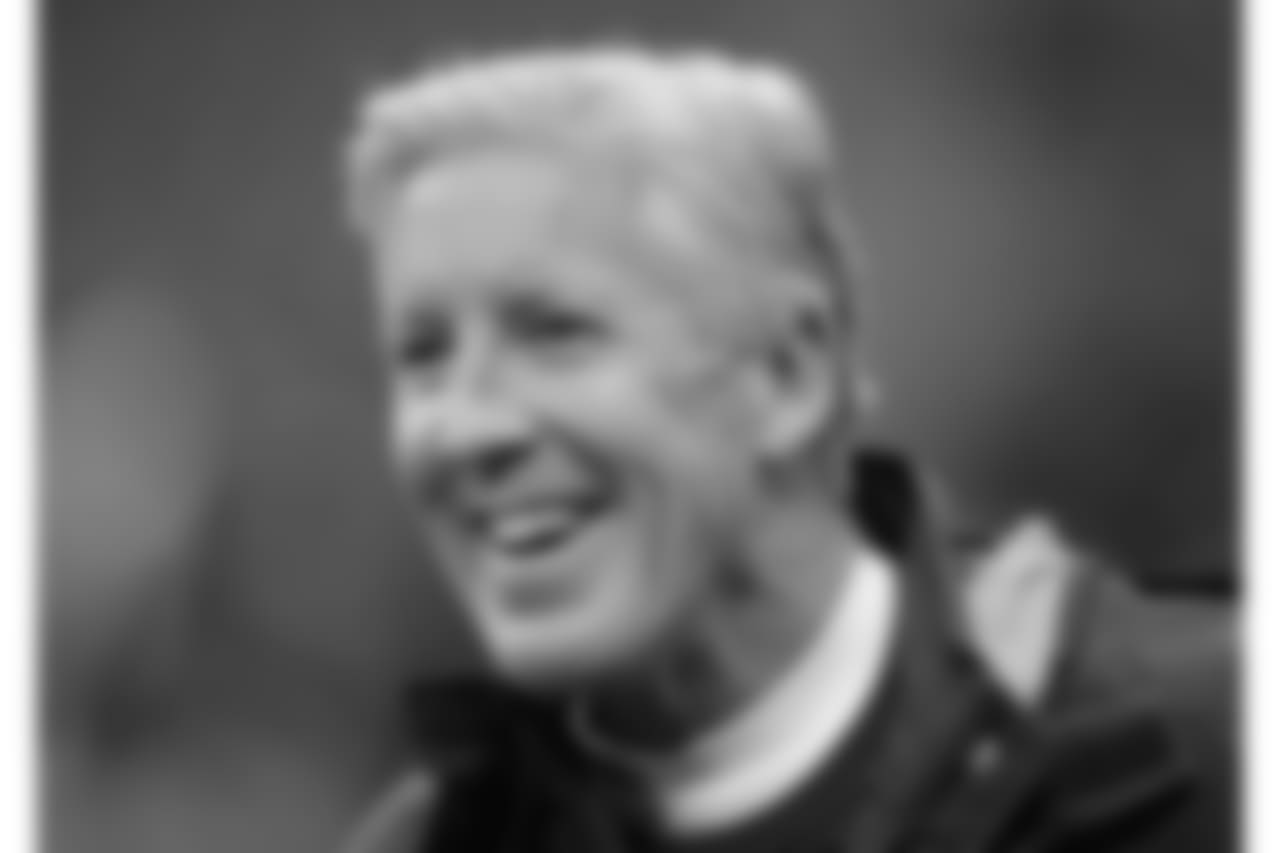 Seattle Seahawks head coach Pete Carroll smiles as he watches his players during the warm-up before an NFL football game against Oakland Raiders at Wembley stadium in London, Sunday, Oct. 14, 2018. (AP Photo/Matt Dunham)