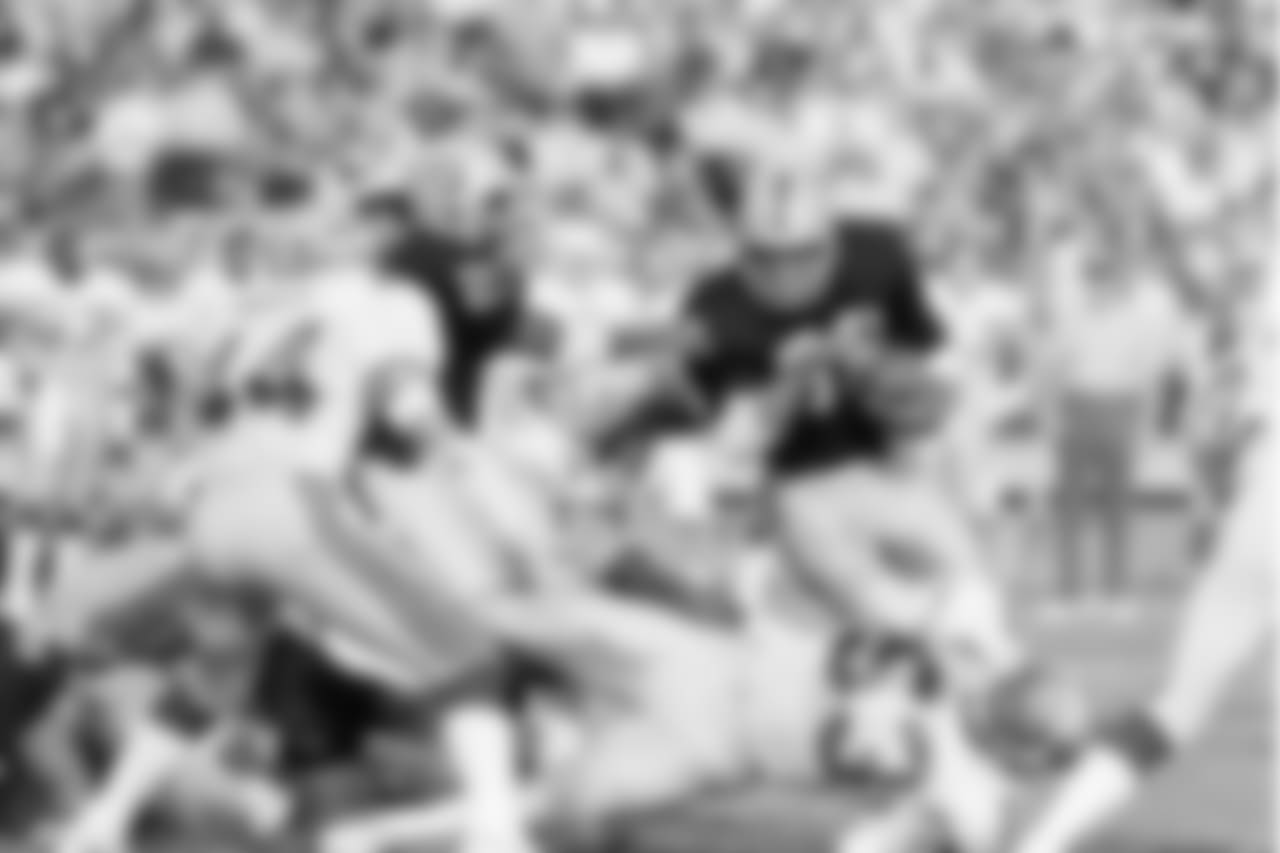 Los Angeles Raiders' running back Marcus Allen (32) makes a short-yardage run against the Seattle Seahawks in Los Angeles, Dec. 15, 1985. Allen is helped by teammate Frank Hawkins (27) while the Seattle defenders are John Harris (44) and Keith Butler (53) in this second quarter play. (AP Photo/Nick Ut)