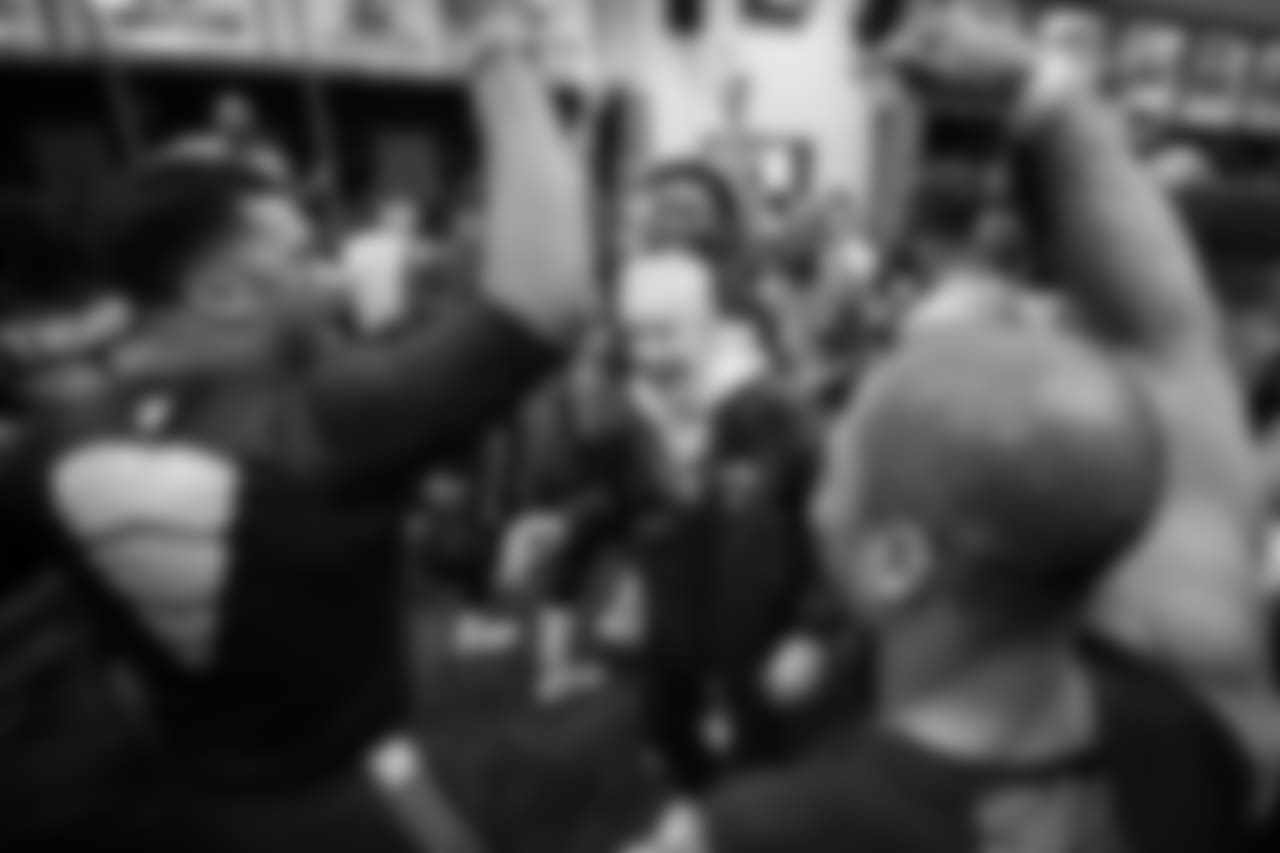 The Seahawks surround head coach Pete Carroll in the jubilant locker room after the win over the Chiefs clinched a playoff spot.
