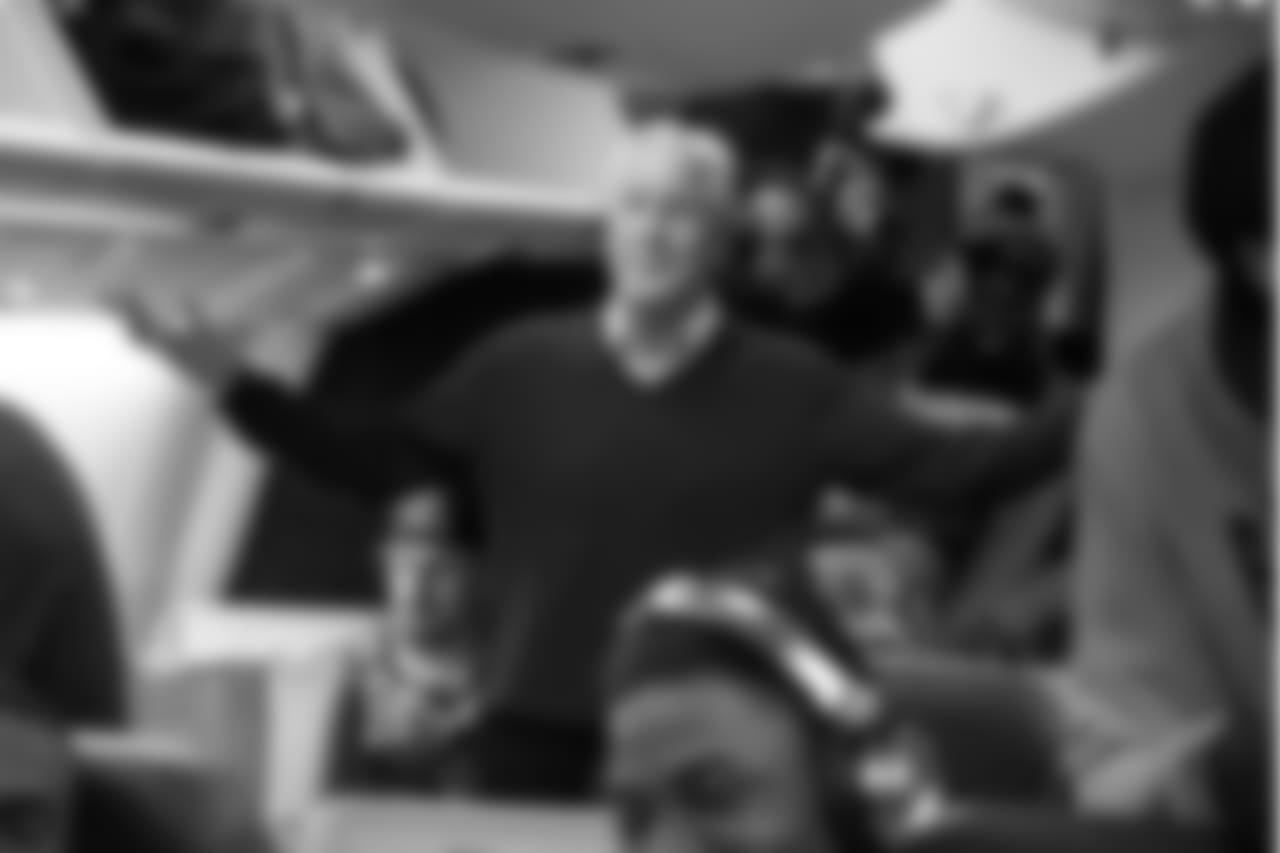 Head coach Pete Carroll, who promised the players that if they won they could have first class seats for the long ride home, comes up from his own coach seat for a quick visit before takeoff.