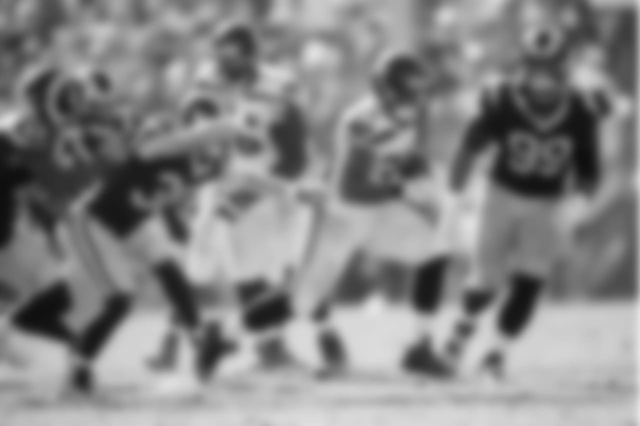 Seattle running back Thomas Rawls runs past a host of Rams.