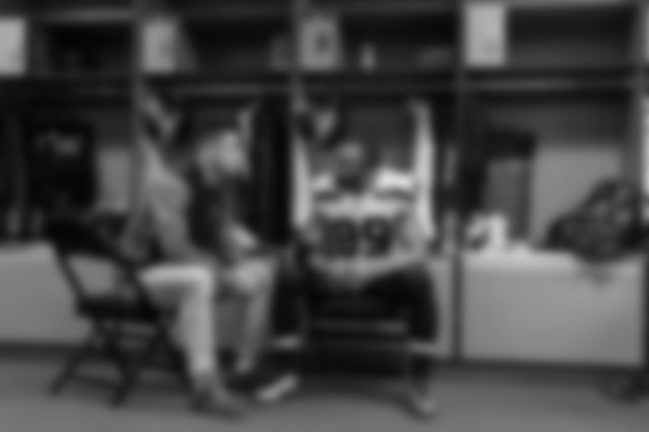 In the visitors locker room, receivers coach David Canales confers with Doug Baldwin prior to the game.