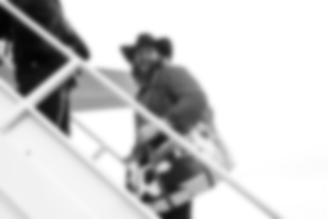 Seahawks offensive lineman Jordan Roos boards the team's charter with his signature cowboy hat with an accompanying Western-themed bag.