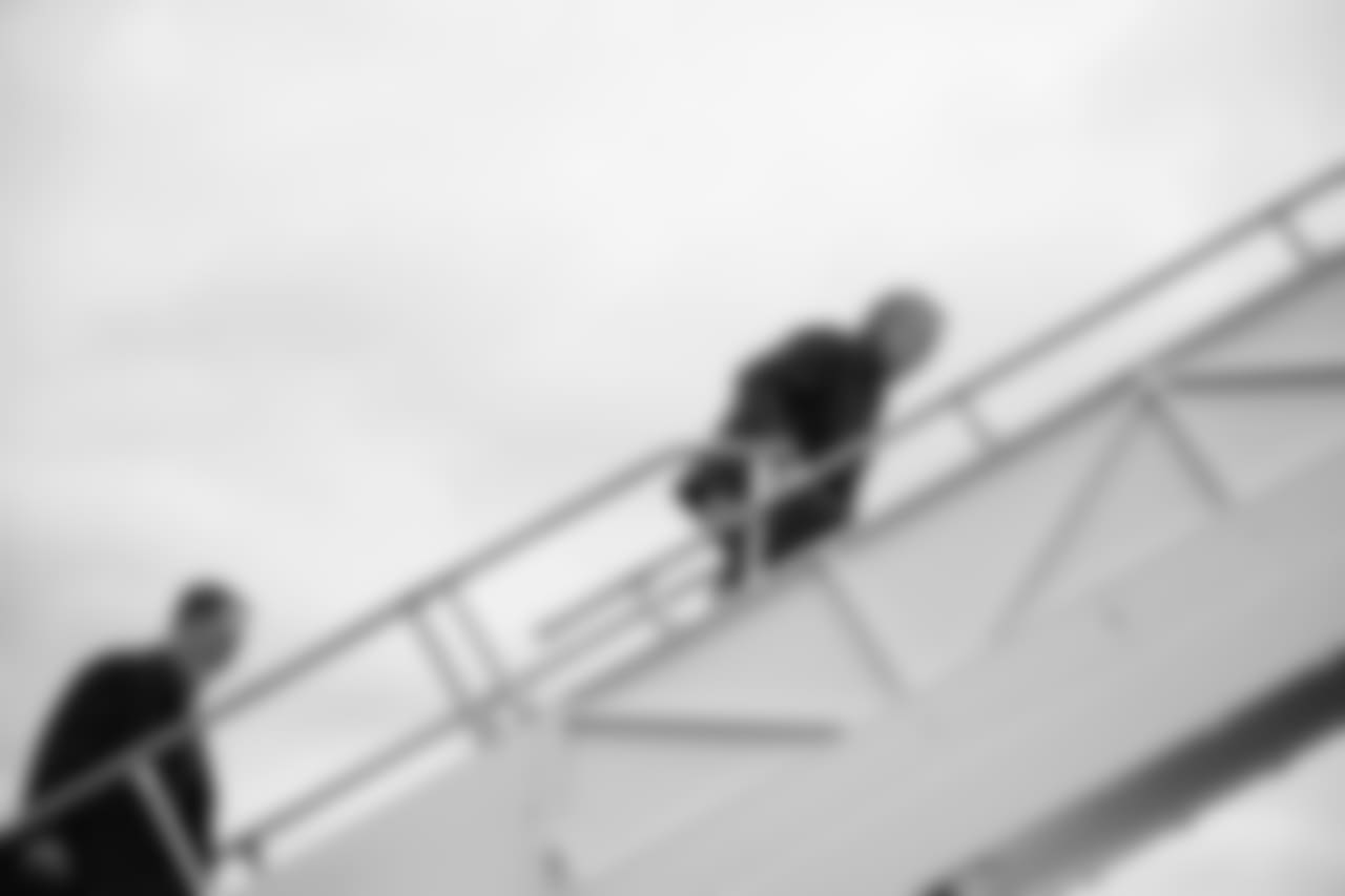 Head coach Pete Carroll and offensive line coach Mike Solari climb the stairs to the charter that would take the team to Dallas.