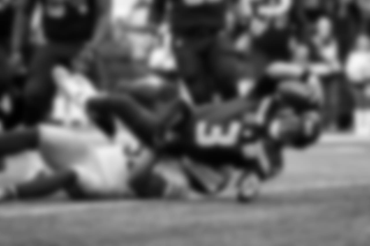 Seahawks quarterback Russell Wilson stretches towards the line to gain for a first down.