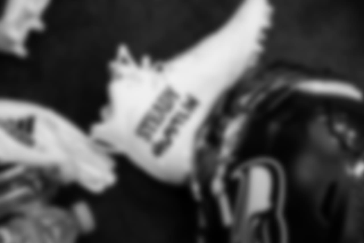 Chris Carson's custom painted cleats lie near his helmet and gloves at his locker.