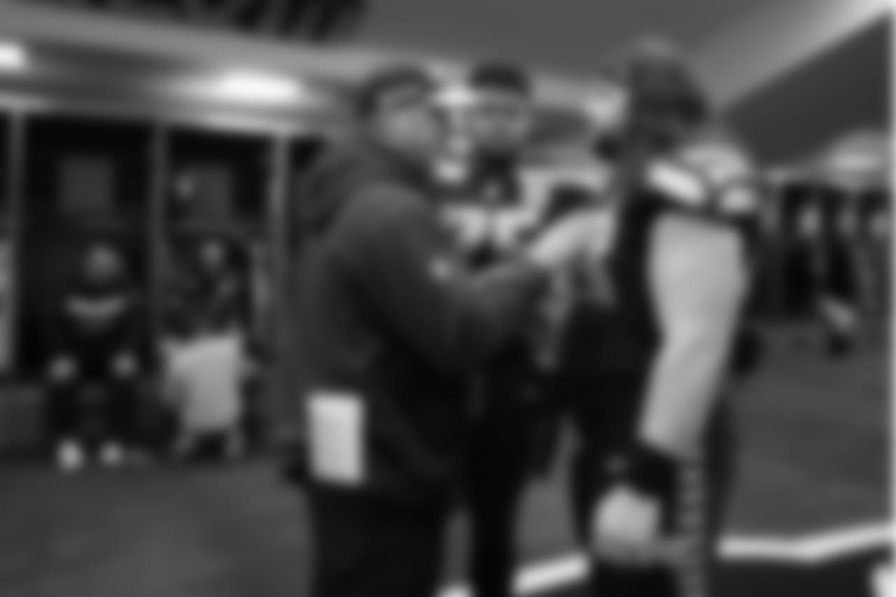 Special teams coach Brian Schneider talks with Elijah Nkansah and Joey Hunt in the locker room during halftime.