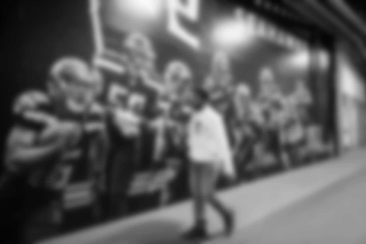 Linebacker Bobby Wagner walks to the Seahawks locker room via a back hallway featuring a wall mural of players including himself.