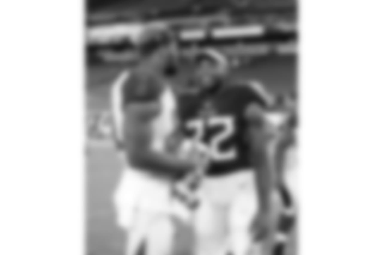 Tampa Bay Buccaneers defensive end Jason Pierre-Paul, left, talks with Tennessee Titans running back Derrick Henry (22) after a preseason NFL football game Saturday, Aug. 18, 2018, in Nashville, Tenn. The Buccaneers won 30-14. (AP Photo/James Kenney)