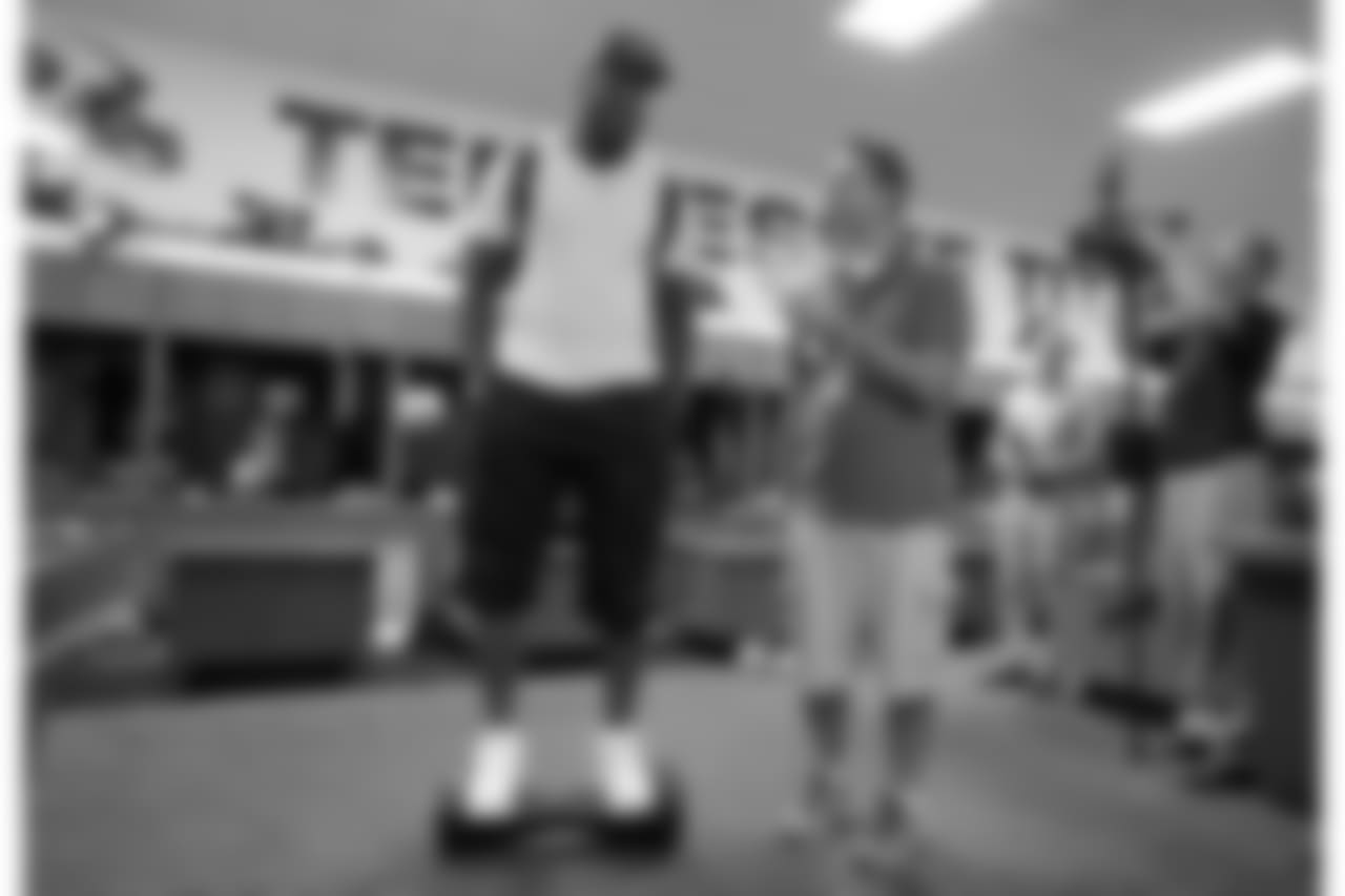 In this Wednesday, Sept. 23, 2015, photo, Tennessee Titans linebacker Brian Orakpo is interviewed in the locker room while riding on a motorized skateboard in Nashville, Tenn. Many of the Titans players use the devices to travel through the team's facility. (AP Photo/Mark Humphrey)