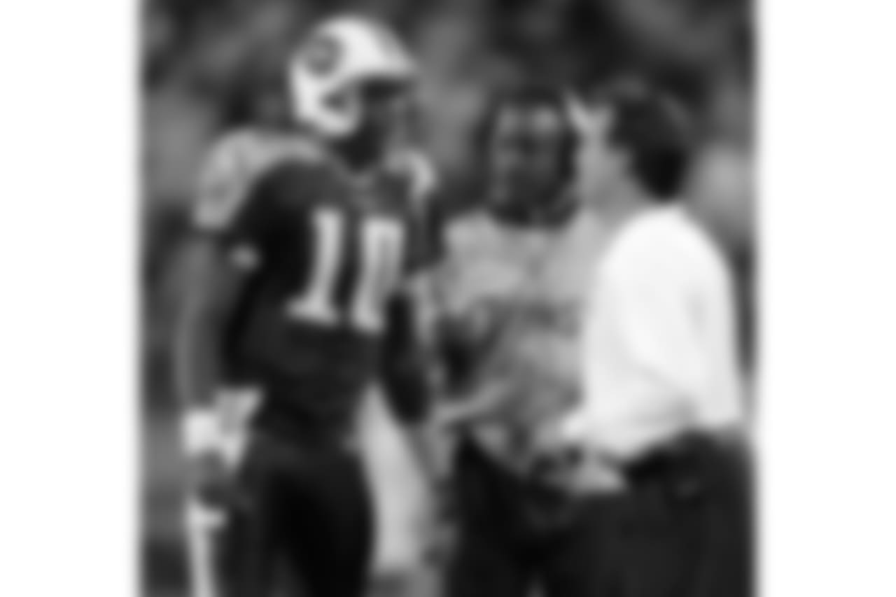 Tennessee Titans quarterback Vince Young (10) talks with head coach Jeff Fisher, right, and quarterbacks coach Craig Johnson in the fourth quarter of an NFL football game against the New York Giants in Nashville, Tenn., Sunday, Nov. 26, 2006. The Titans defeated the Giants, 24-21. (AP Photo/Mark Humphrey)