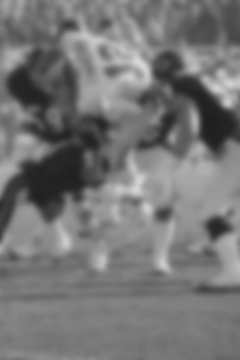 Philadelphia Eagles Randall Cunningham (12) is brought down by Chicago Bears defenders Jim Morrissey (51), Dan Hampton (99) and Ron Rivera (59) during first half action, Saturday, Dec. 31, 1988 in their semi-final NFC playoff game in Chicago. (AP Photo/Mark Elias)