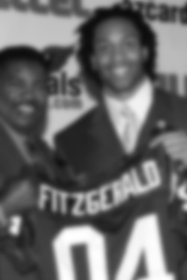 First-round pick Larry Fitzgerald holds up his jersey with coach Dennis Green during Fitz's introductory press conference in 2004