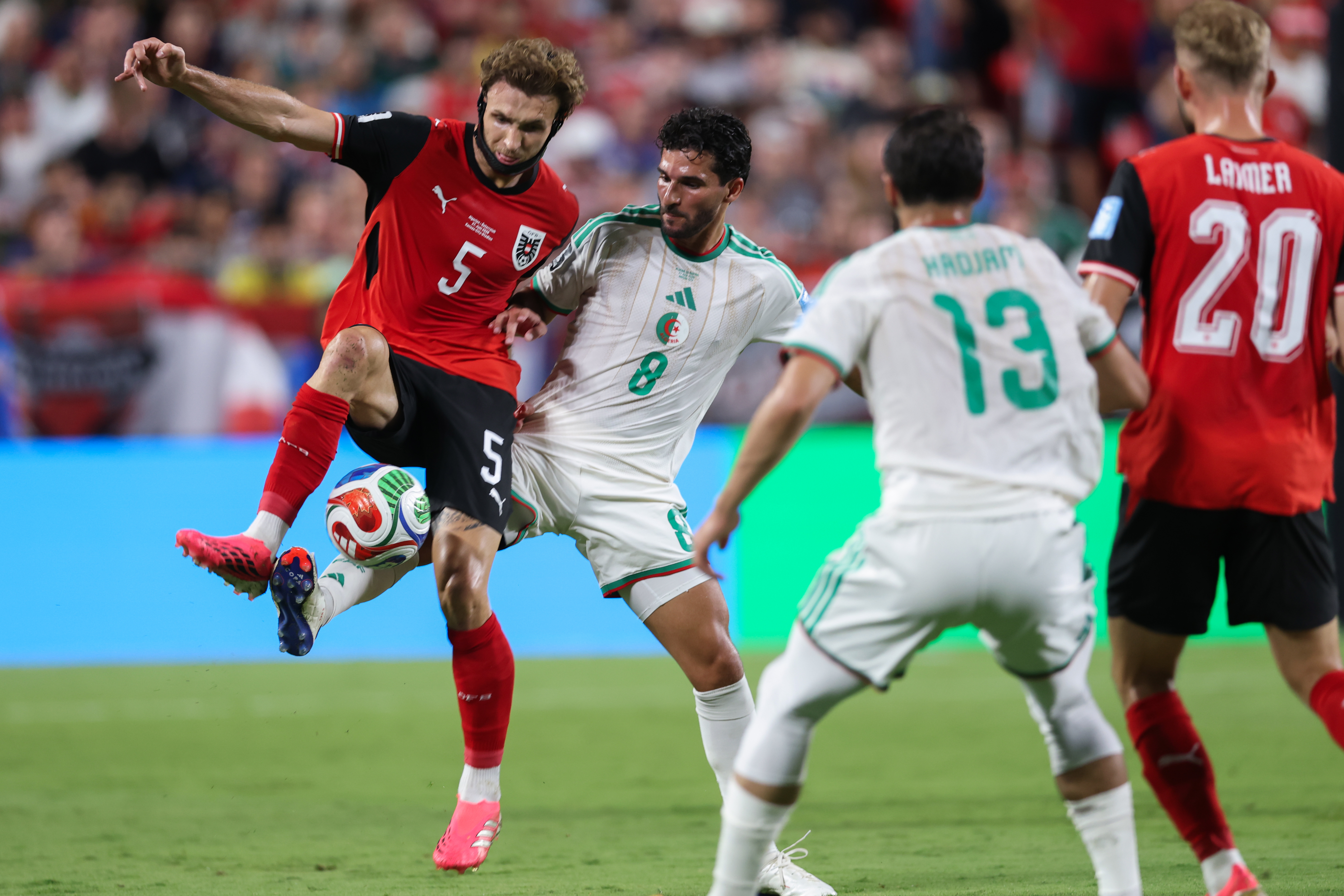 Stefan Posch, Austria, and Houssem Aoua, Algeria, battle for possession of the ball