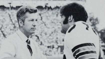 New Orleans Saints team physician Ken Saer examines what turned out to be a broken bone in linebacker Tom Roussel's arm.