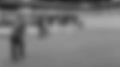 Tight end Trey McBride lines up a putt at the TPC Scottsdale on Wednesday, as Denzel Burke, Budda Baker and Zaven Collins look on.