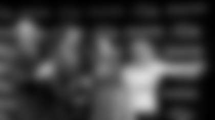 John Harbaugh, second from left, his father Jack, far left, wife Ingrid, and his mother Jackie, far right, motion for his daughter, Alison, to join them for a group photo after John was introduced as the new coach of the Baltimore Ravens football team during a news conference, Saturday, Jan. 19, 2008, in Owings Mills, Md. (AP Photo/Rob Carr)