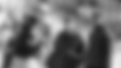 Carolina Panthers' Cam Newton, right, and offensive coordinator Mike Shula, center, watch Derek Anderson, left, warm up before an NFL football game against the Tampa Bay Buccaneers in Charlotte, N.C., Sunday, Dec. 14, 2014. Newton will not play in the game after being injured in a car accident on Tuesday. (AP Photo/Mike McCarn)