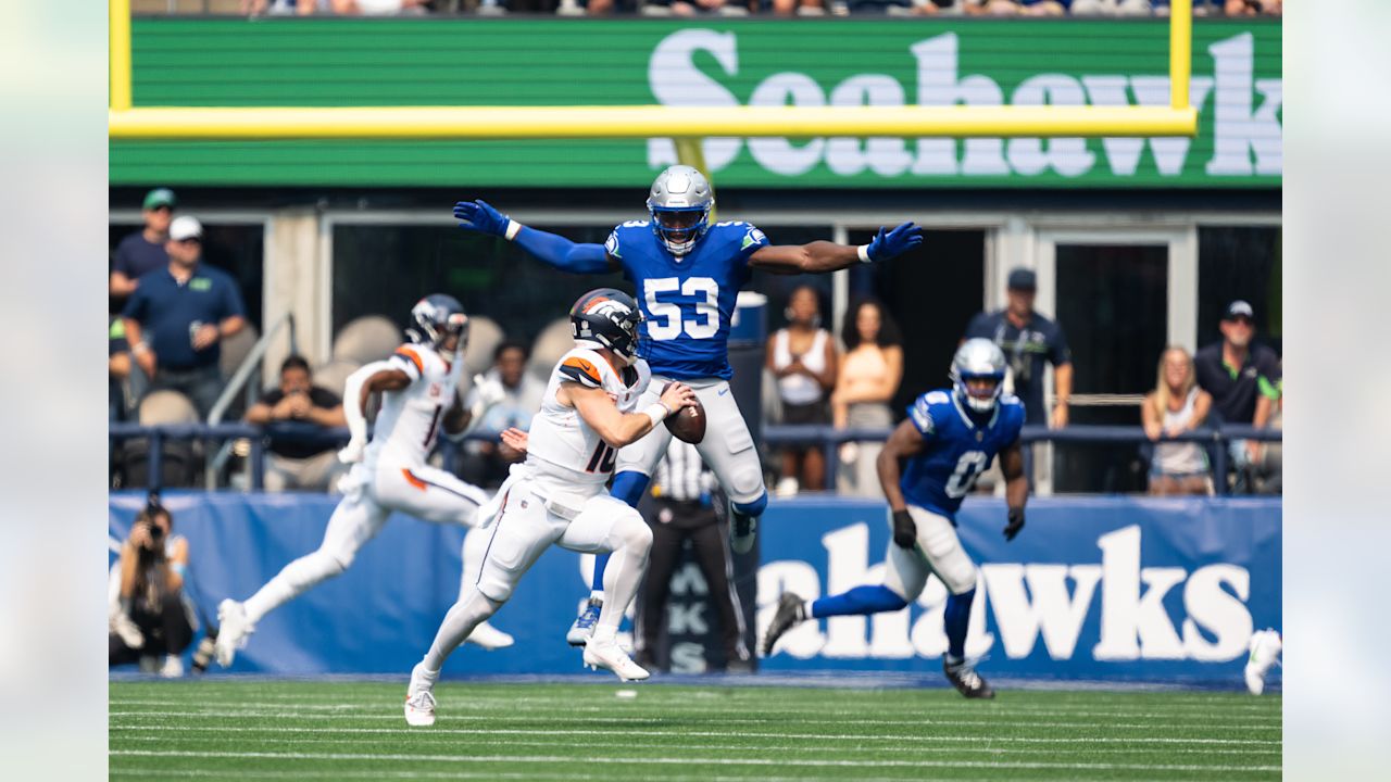 Seahawks outside linebacker Boye Mafe leaps to take away a pass as Broncos quarterback Bo Nix looks for another option.