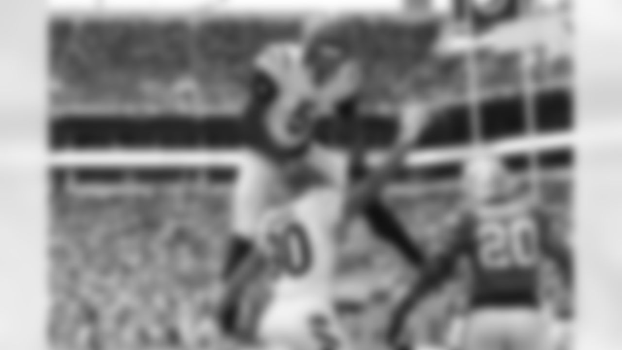 Cincinnati Bengals wide receiver Tee Higgins (5) leaps onto running back Chase Brown (30) after Brown's touchdown during the second half of an NFL football game against the Miami Dolphins, Sunday, Dec. 21, 2025, in Miami Gardens, Fla. (AP Photo/Rebecca Blackwell)