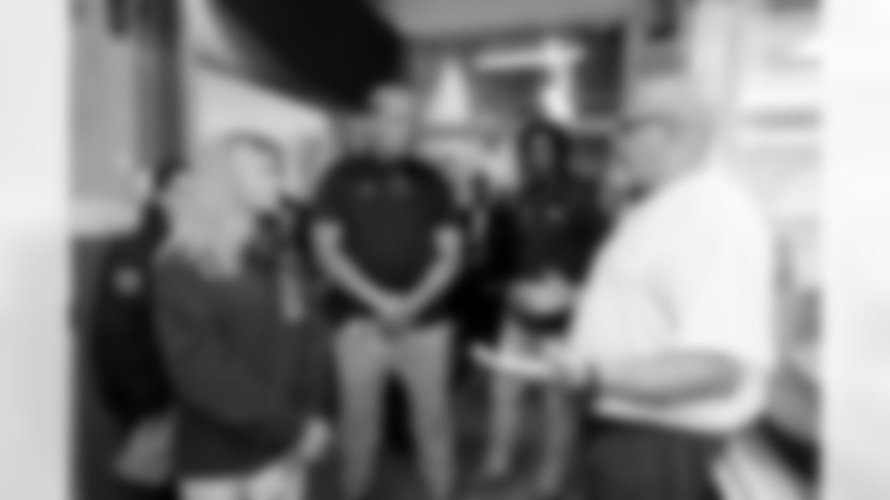 An inmate talks about his artwork with Carrie Walton Penner, Garett Bolles and Pat Bryant during a visit to the Arkansas Valley Correctional Facility in Ordway, Colorado on October 14, 2025. In partnership with the Vera Institute of Justice, the Denver Broncos Foundation toured ChangeMakers Village (a Restoring Promise Unit).Photo by Gabriel Christus / Denver Broncos