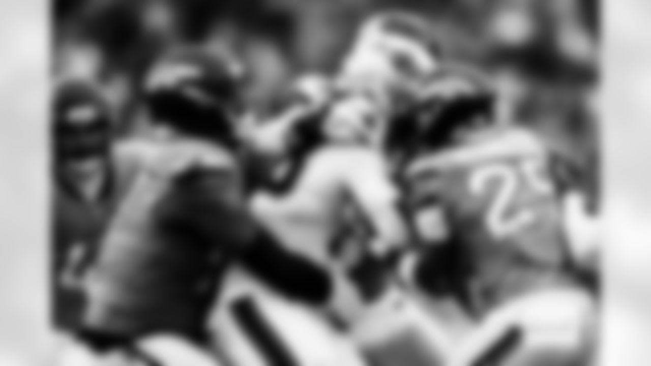 Denver Broncos defensive tackle Malcolm Roach (97) and cornerback Ja'Quan McMillian (29) wrap up New England Patriots running back Rhamondre Stevenson (38) during the AFC Championship Game between the Denver Broncos and New England Patriots at Empower Field at Mile High in Denver, Colorado on January 25, 2026. Photo by Ben Swanson / Denver Broncos