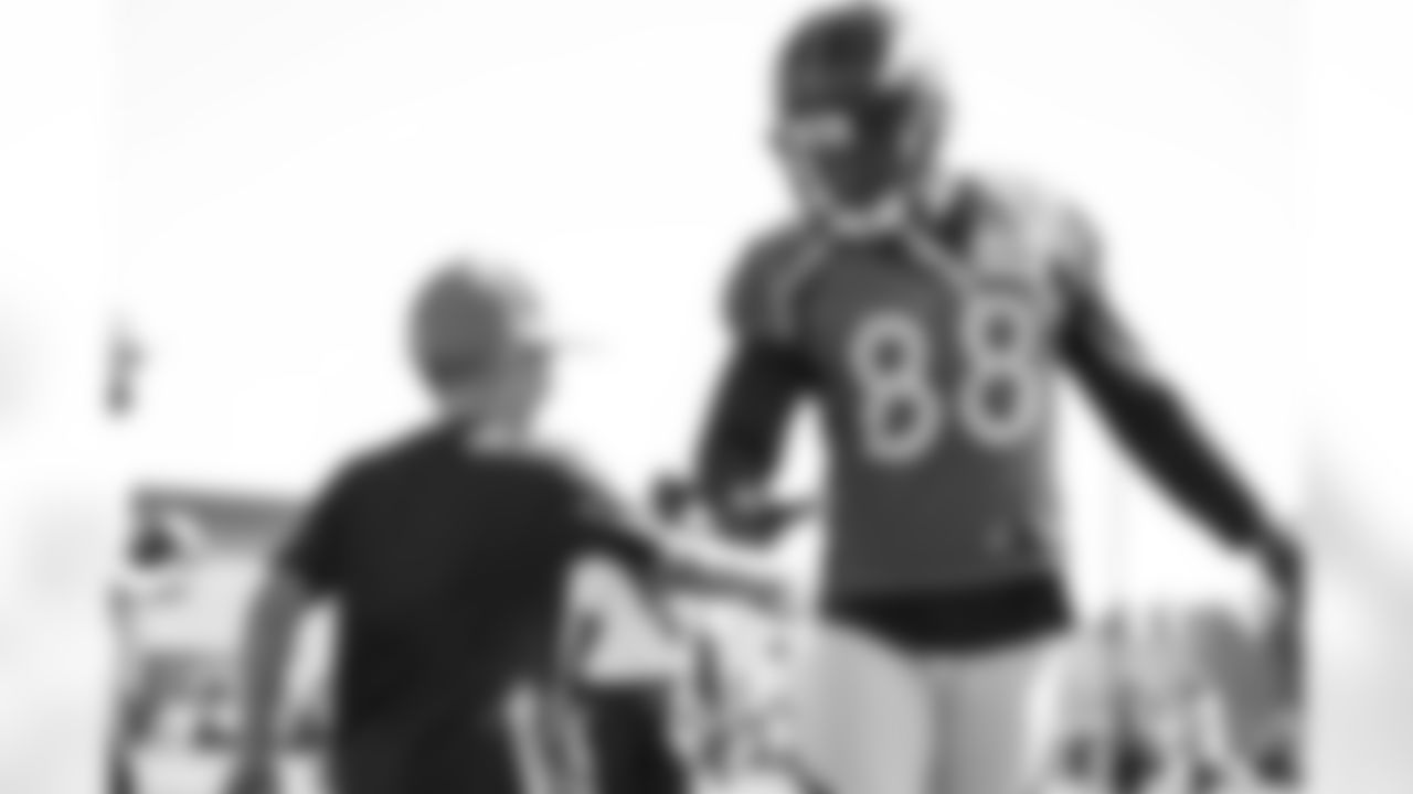 Wide receiver Demaryius Thomas (88) shakes hands with the son of a Broncos staff member at training camp practice on July 28, 2017. (Ben Swanson)