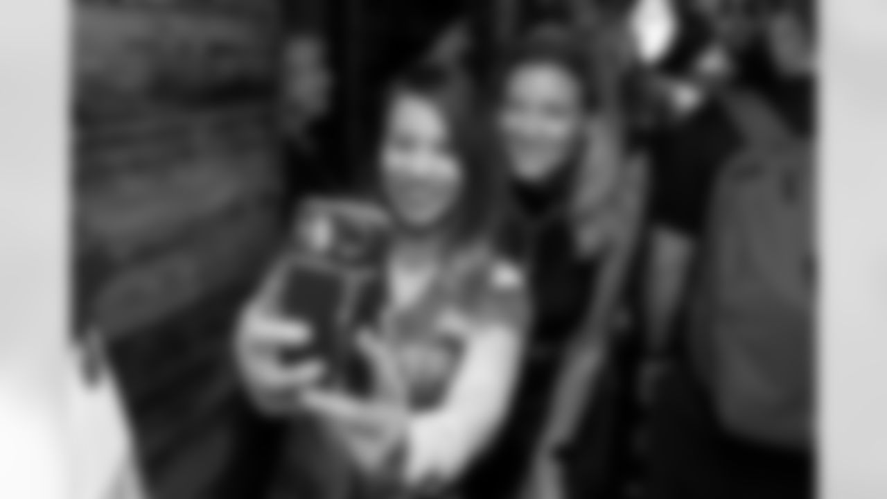 Carrie Walton Penner takes a photo with a fan at the Broncos Pub at The Admiralty Pub in Trafalgar Square in London, England on October 11, 2025. Photo by Gabriel Christus / Denver Broncos