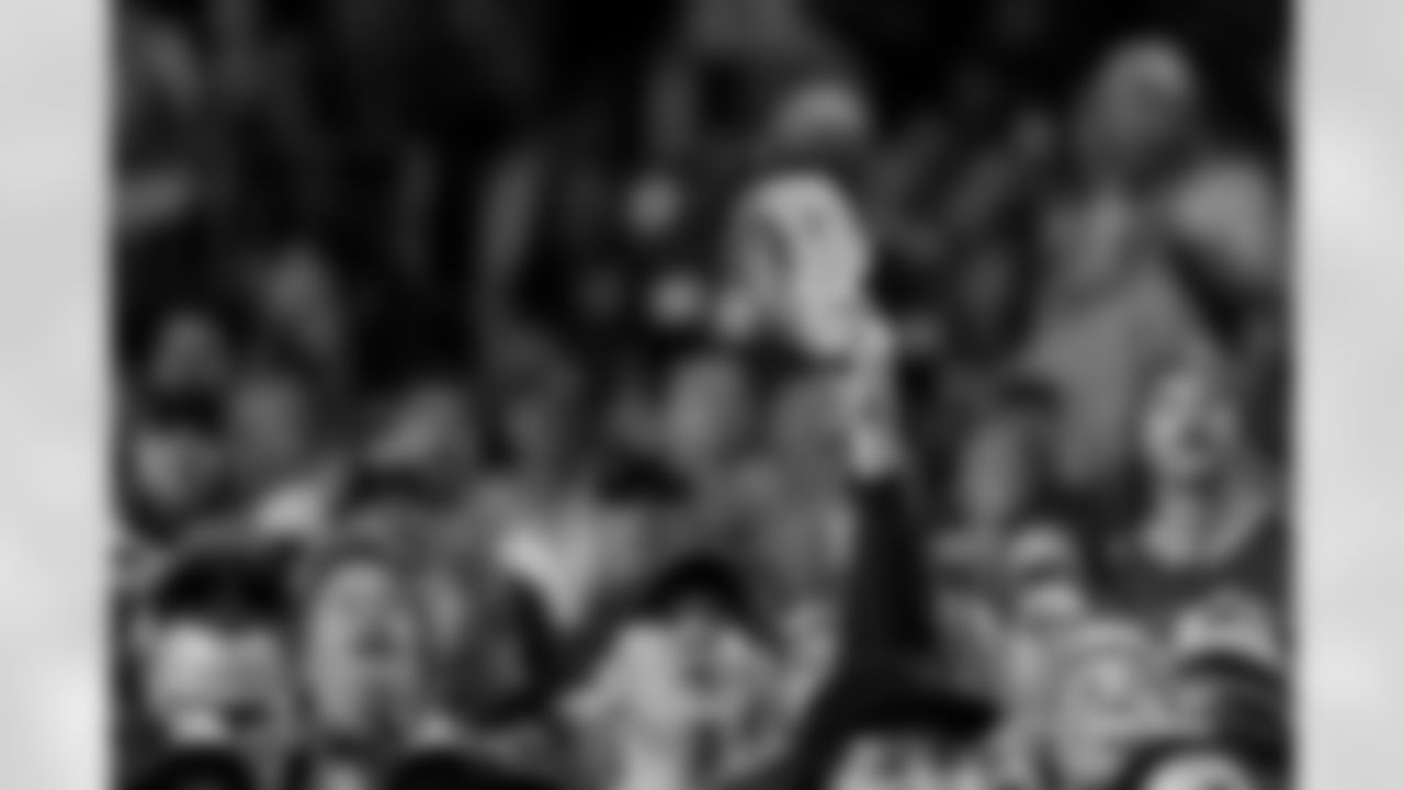 A fan waves a cutout of Bo Nix's face during the Broncos' Week 15 game against the Green Bay Packers at Empower Field at Mile High in Denver, Colorado on December 14, 2025. Photo by Ben Swanson / Denver Broncos